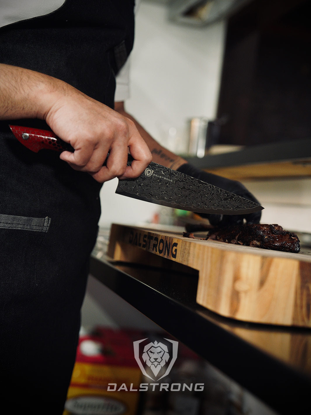 Dalstrong lionswood colossal teak cutting board with cooked meat on top of a kitchen table.