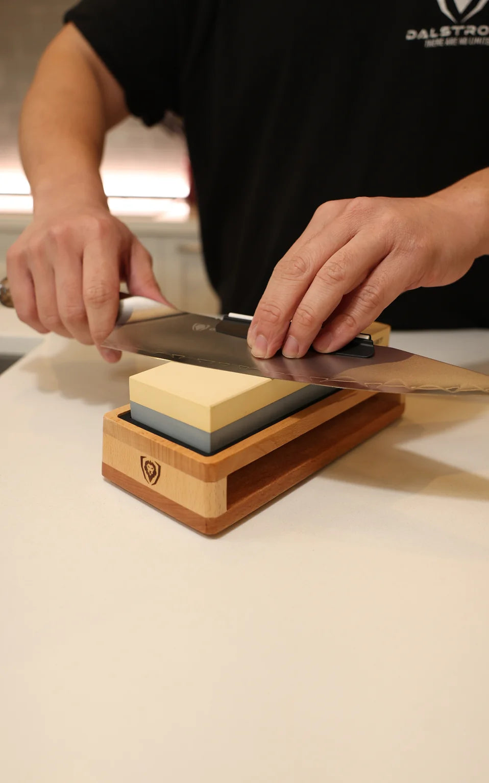Sharpening a chef knife on the 1000/6000-grit whetstone in its beech wood base
