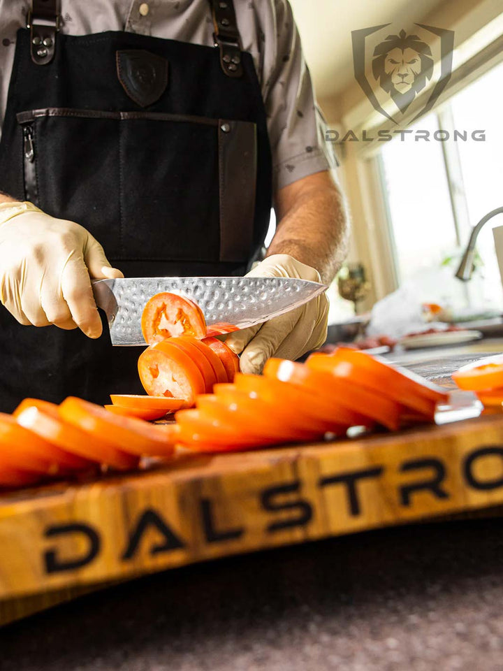 Slicing tomatoes with the Dalstrong 8 inch chef knife on top of a Dalstrong wooden board.