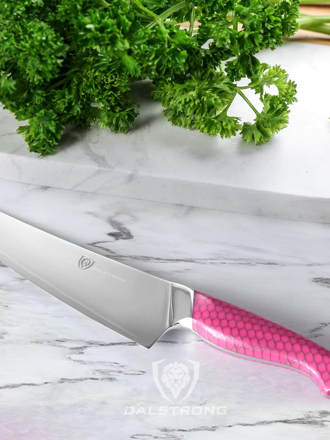 Dalstrong frost fire series 8 inch chef knife with pink handle and parsley on a white board.