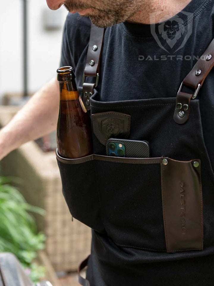 Dalstrong heavy-duty waxed canvas bbq apron with a beer bottle and phone inside.