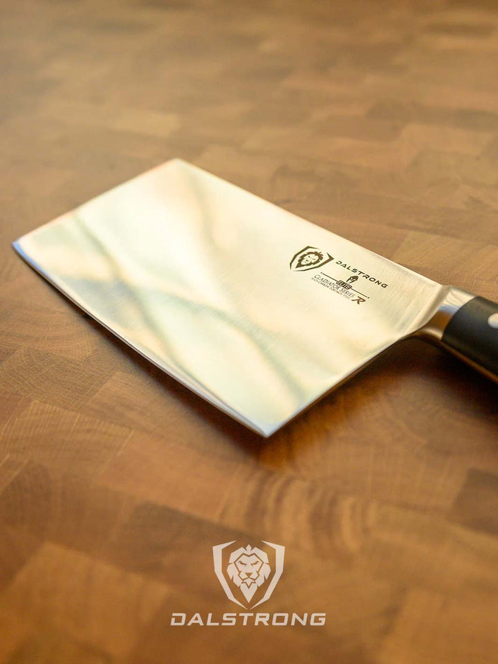 Dalstrong gladiator series 9 inch chinese cleaver with black handle on top of a cutting board.