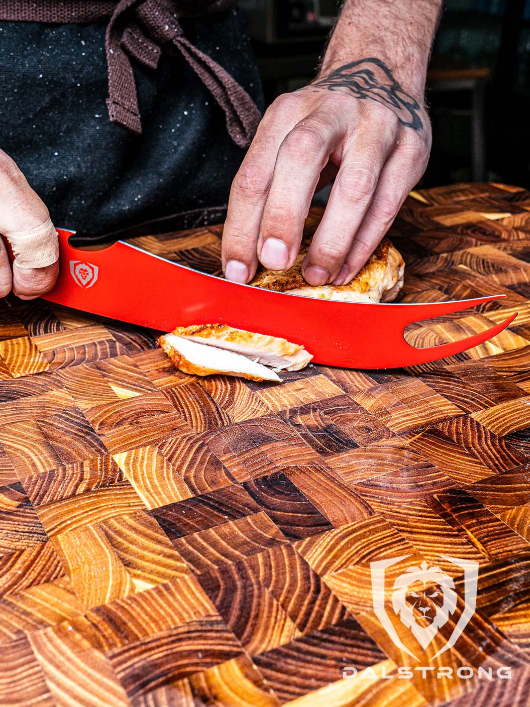 Dalstrong shadow black series 9 inch pitmaster knife red edition with a sliced chicken on a cutting board.