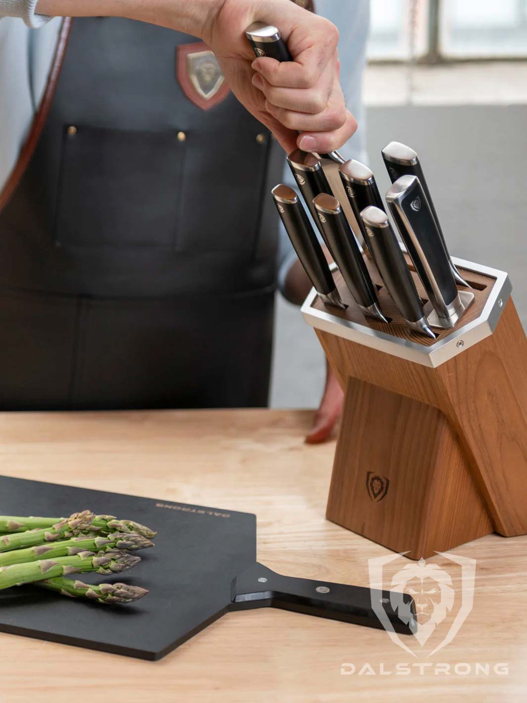 Dalstrong vanquish series 8 piece knife block set with cutting board on a table.
