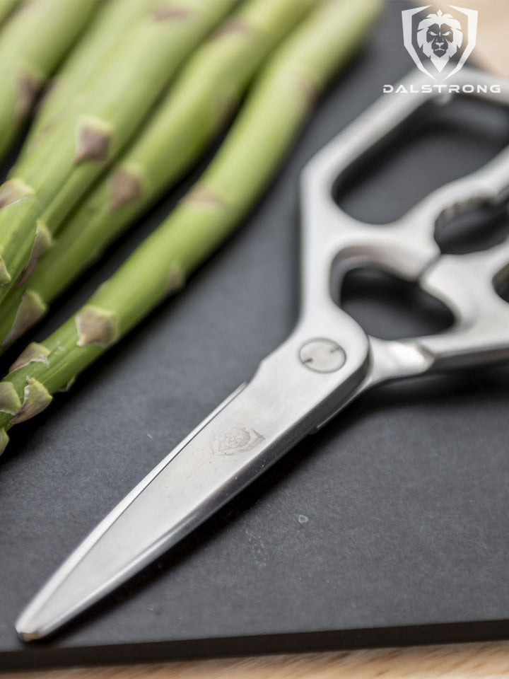 Dalstrong professional kitchen scissors with asparagus beside it.