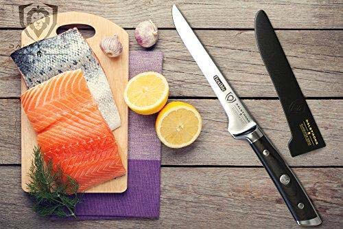 Dalstrong gladiator series 6 inch boning knife with black handle and two fillets of salmon on a wooden board.