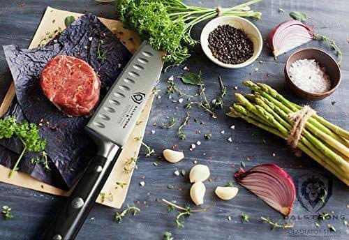 Dalstrong gladiator series 5 inch santoku knife with black handle and a piece of steak beside it.
