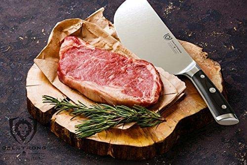 Dalstrong gladiator series 9 inch ravager cleaver knife with black handle beside a big piece of steak on a wooden board.