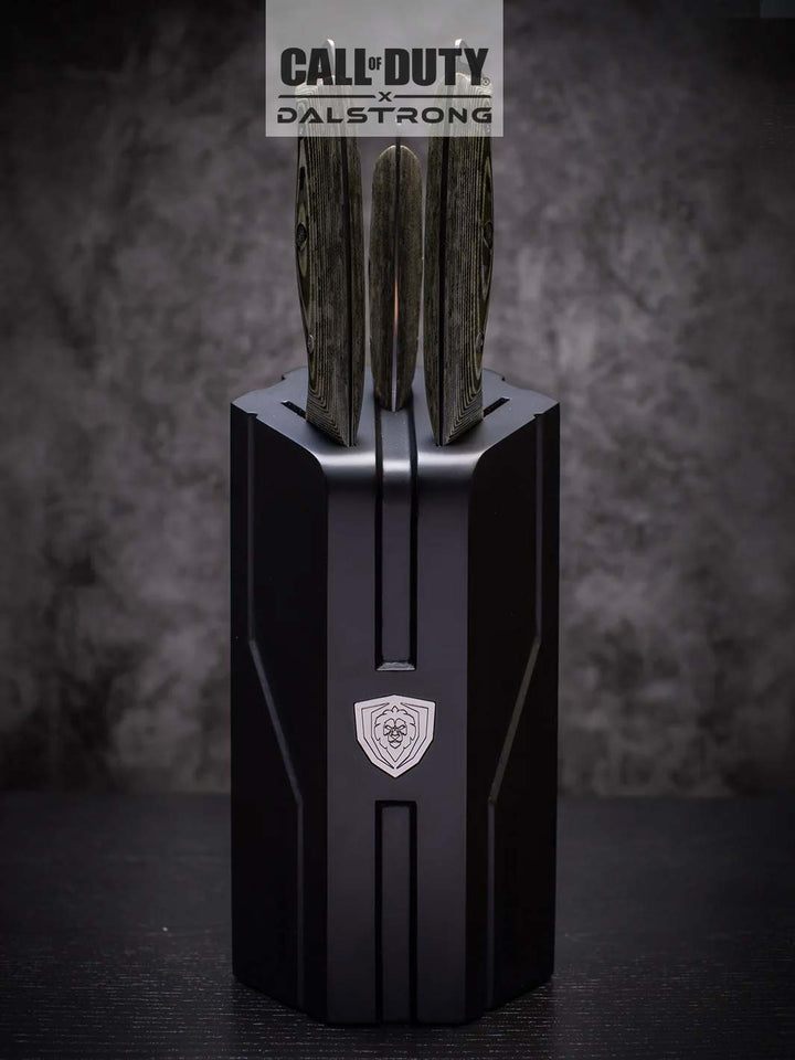 Dalstrong call of duty series 3 piece knife set inside it's knife block on top of a black table.