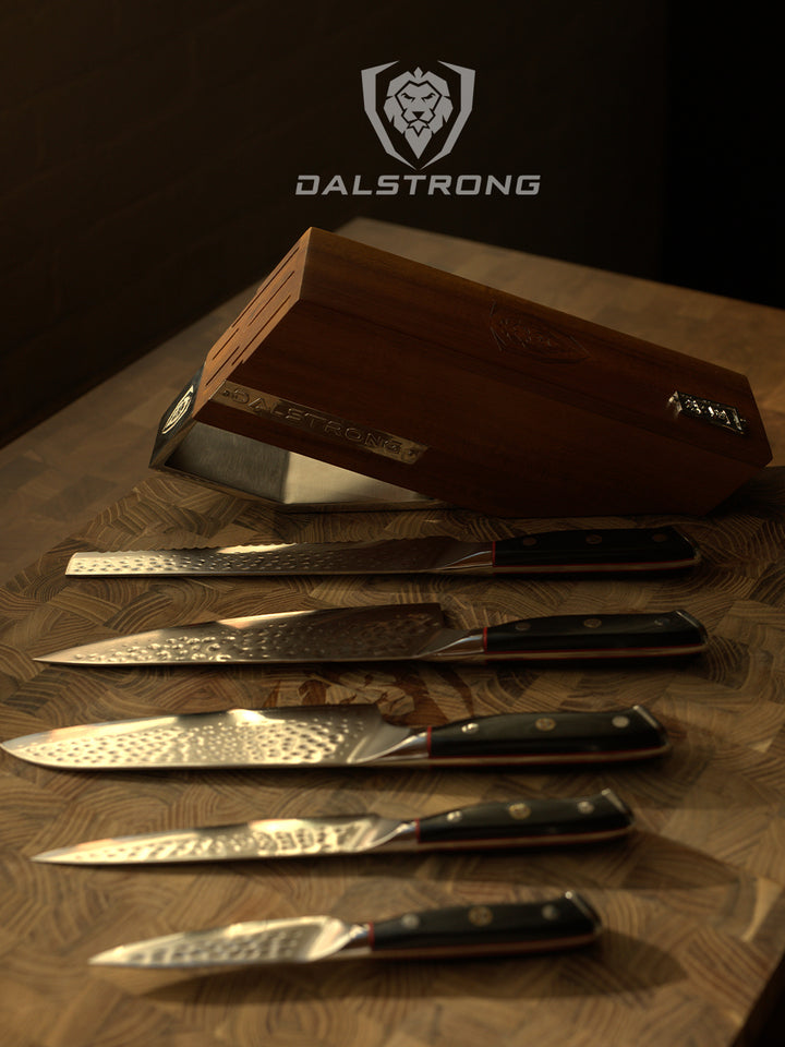 Dalstrong shogun series 5 piece knife set with block and black handles on top of a Dalstrong wooden board.