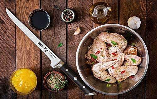 Gladiator series 8 inch boning knife with black handle and marinated chicken wings on a bowl.