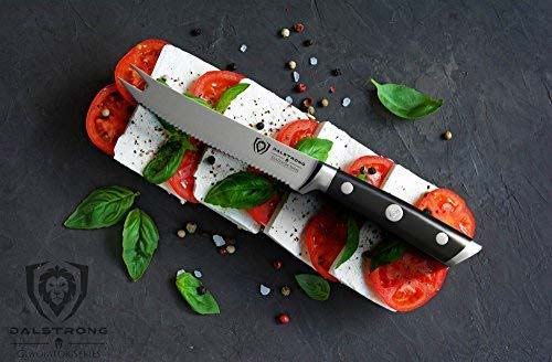 Dalstrong gladiator series 5 inch tomato knife with black handle and sheath on top of a tomato and cheese.