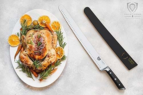 Dalstrong gladiator series 14 inch serrated slicer knife with black handle and roasted whole chicken on a plate.