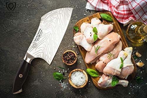 Dalstrong omega series 7 inch cleaver knife with cuts of chicken meat on a cutting board.
