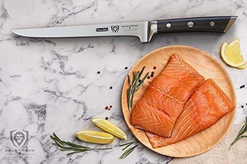 Gladiator series 8 inch boning knife with black handle and two fillets of salmon on a wooden plate.