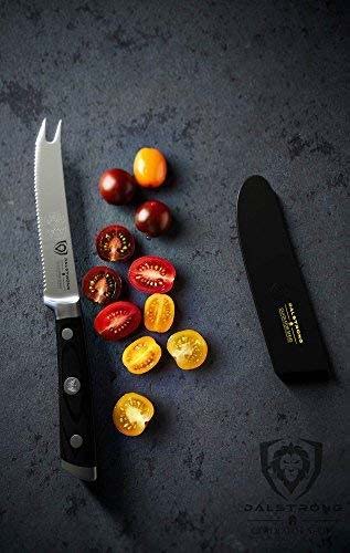 Dalstrong gladiator series 5 inch tomato knife with black handle and sheath beside slices of tomatoes.