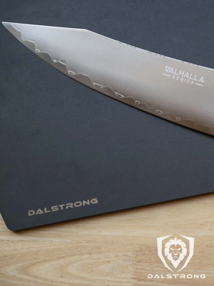 Dalstrong valhalla series 9.5 inch chef knife with wooden handle featuring it's blade.