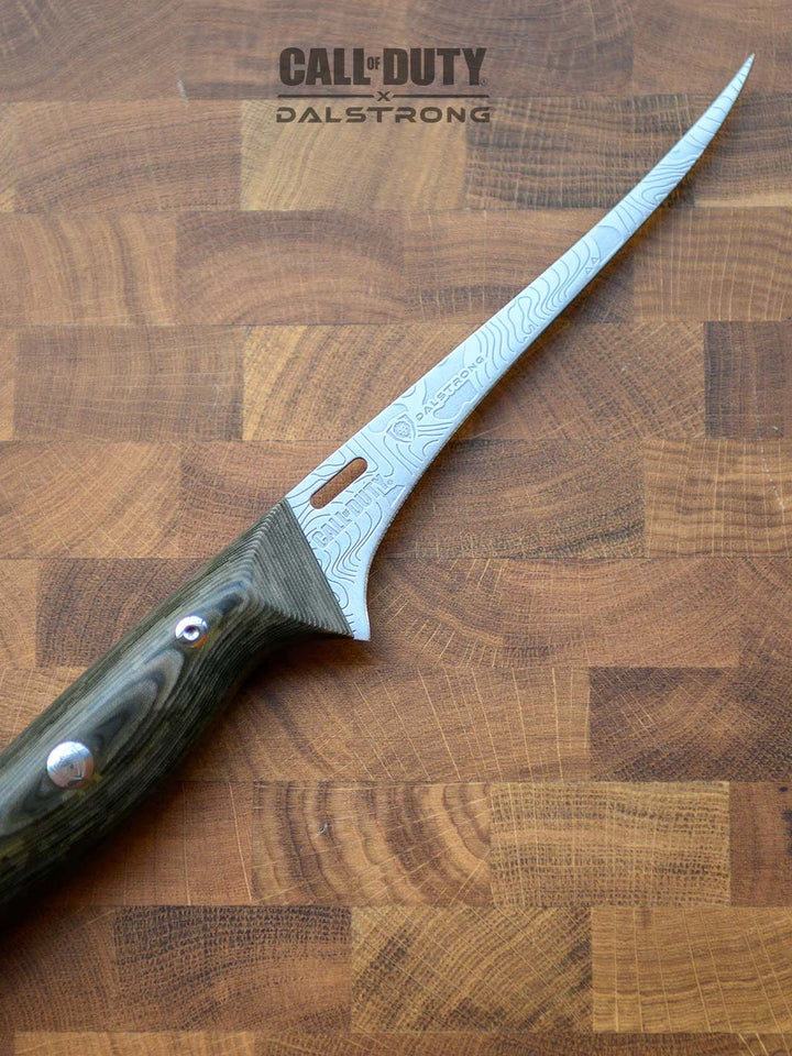 Dalstrong call of duty series 6 inch fillet knife on a cutting board.