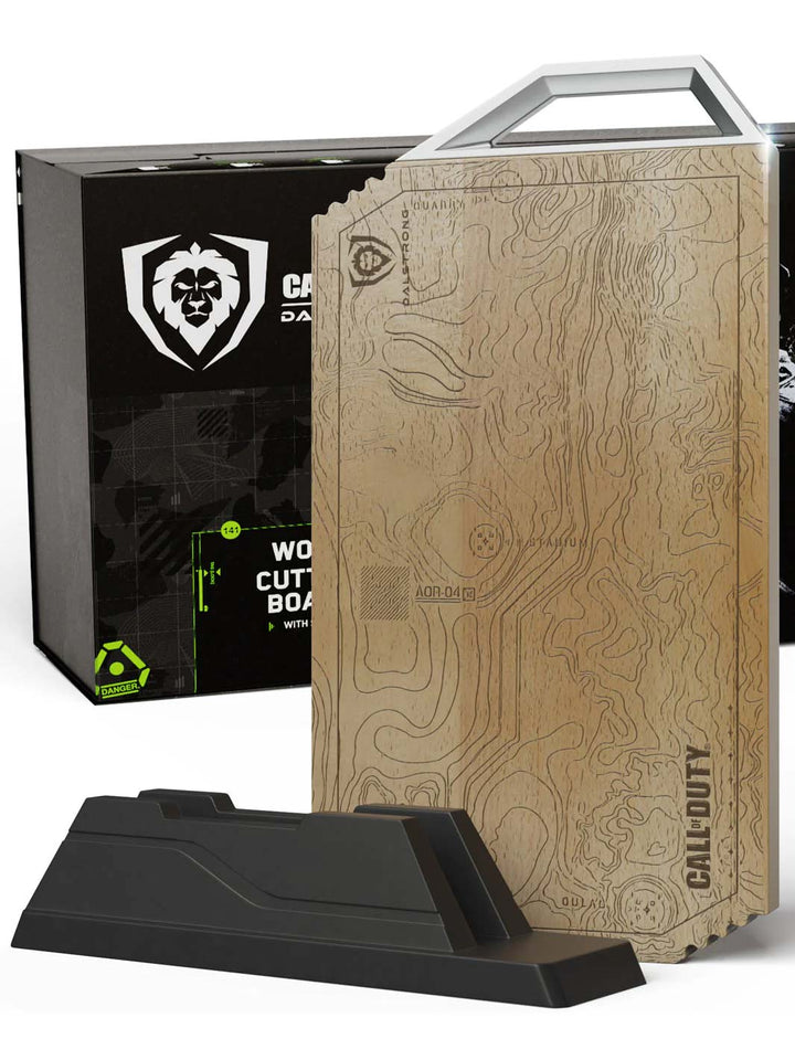 Dalstrong call of duty edition cutting board with rubberwood stand in front of it's premium packaging.