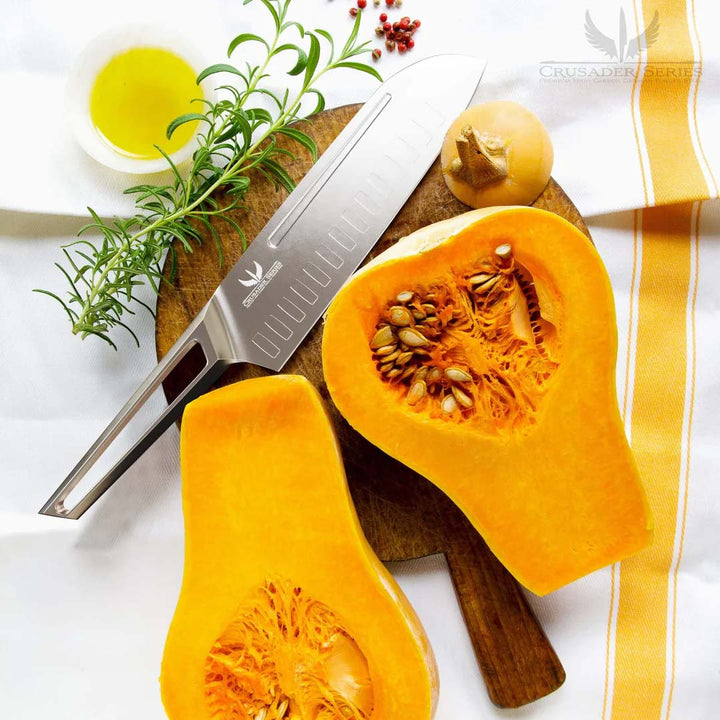 Dalstrong crusader series 7 inch santoku knife with german steel handle with butternut squash cut in half.