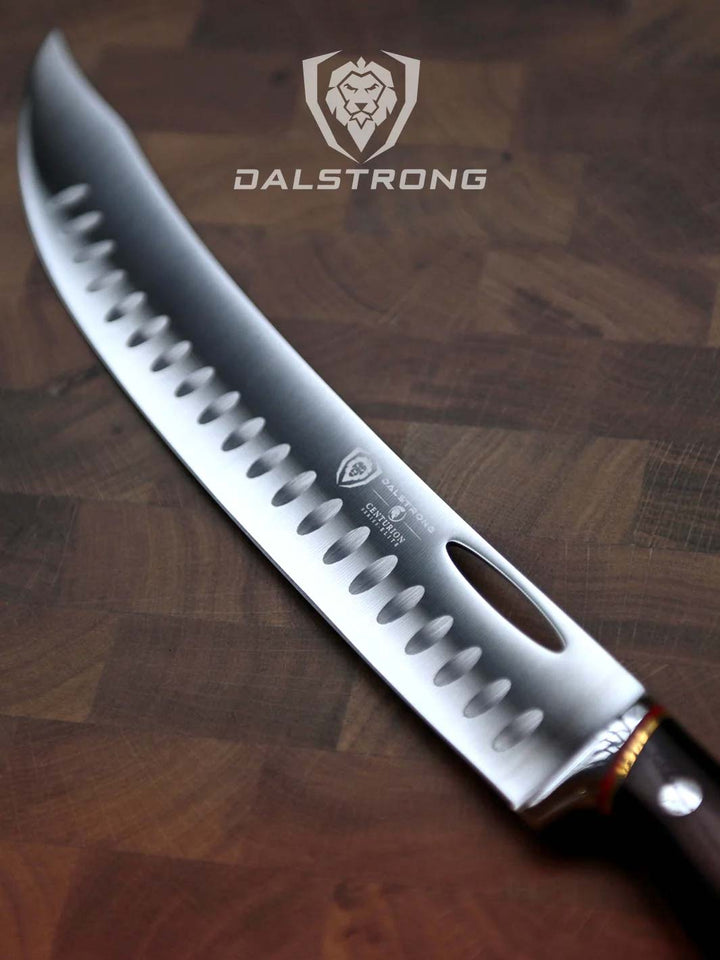 Dalstrong centurion series 10 inch butcher and breaking knife with black handle on a cutting board.