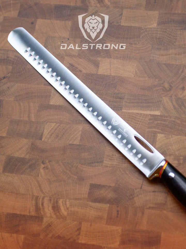 Dalstrong centurion series 12 inch slicing and carving knife with black handle on a cutting board.