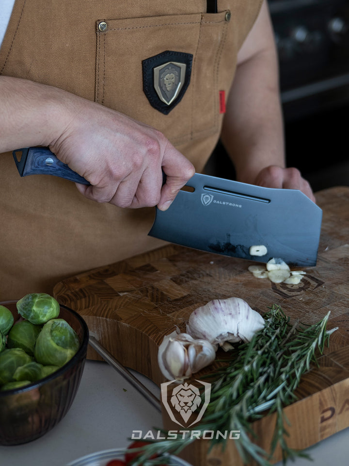 Dalstrong delta wolf series 7 inch cleaver knife with thin slices of garlic.