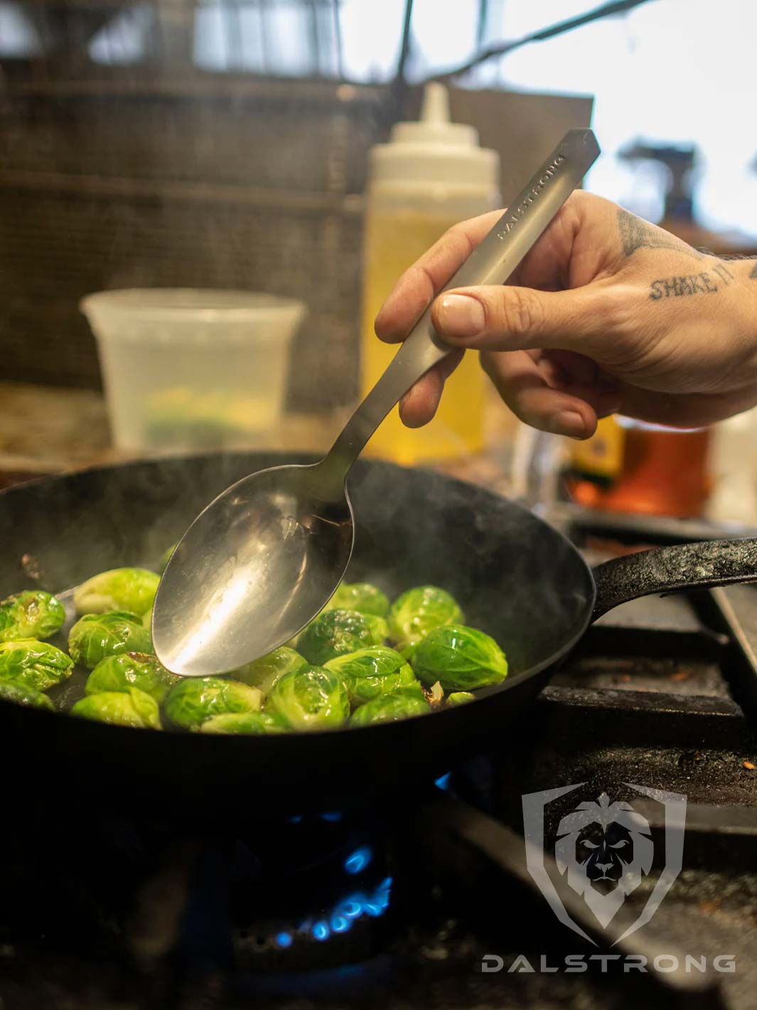 Dalstrong professional chef tasting and plating spoon on top of a brussel sprouts.