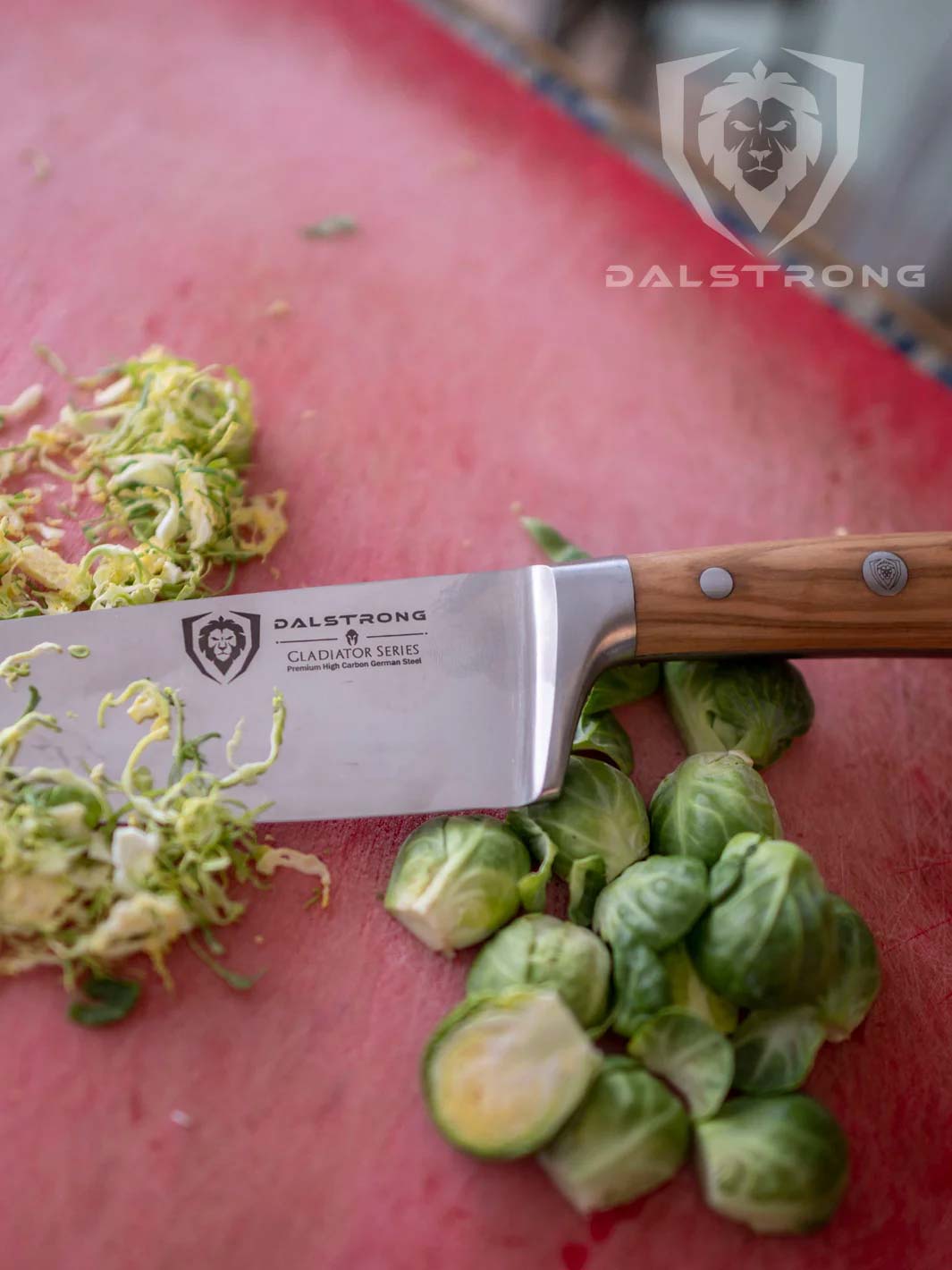 Dalstrong gladiator series 8 inch chef knife with olive wood handle and chopped brussel sprouts.