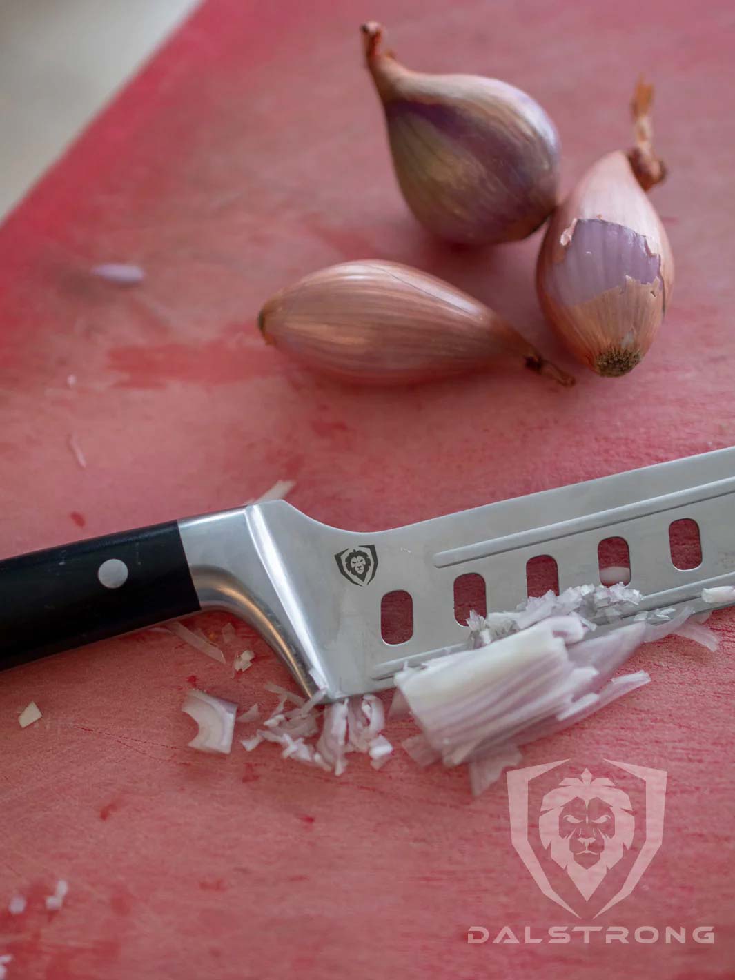 Dalstrong gladiator 6 inch offset nakiri knife with black handle and onions at the top of it.