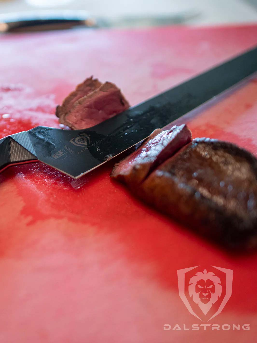 Dalstrong shadow black series 12 inch offset slicer knife with slices of steak on the side.