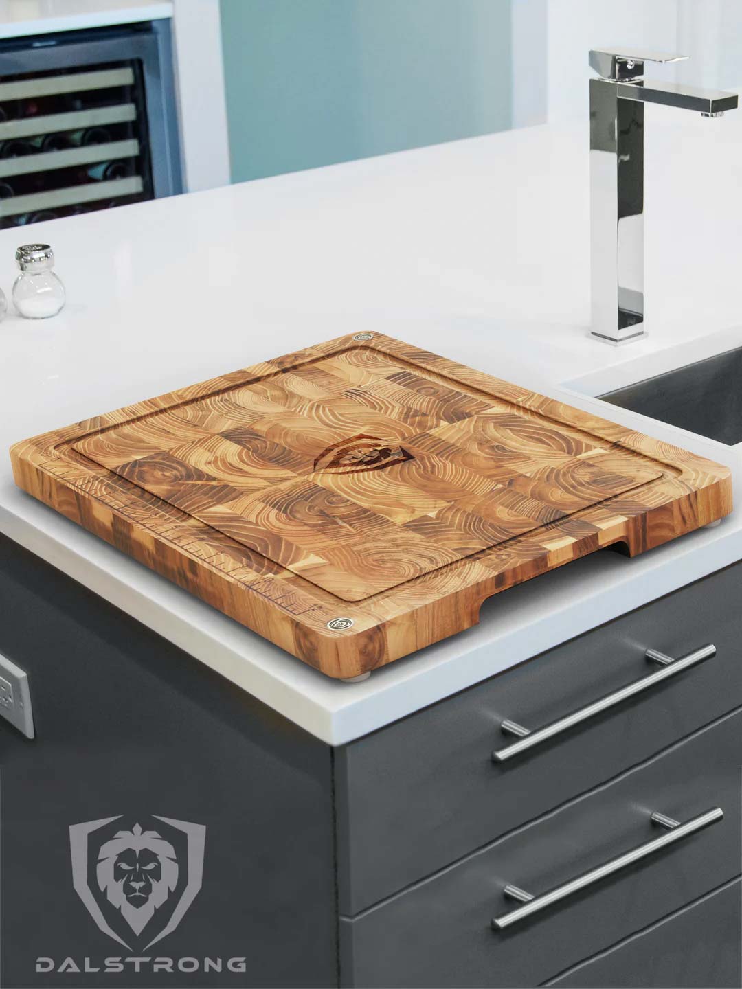 Dalstrong teak cutting board medium size on top of a kitchen table.