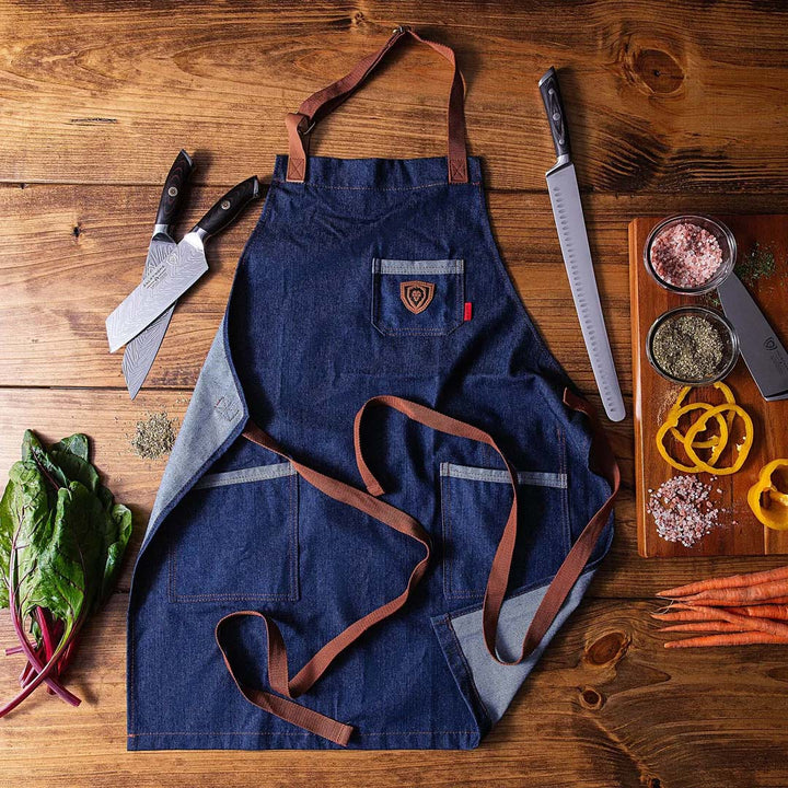 Dalstrong american legend blue denim professional chef's kitchen apron with dalstrong knives beside it.
