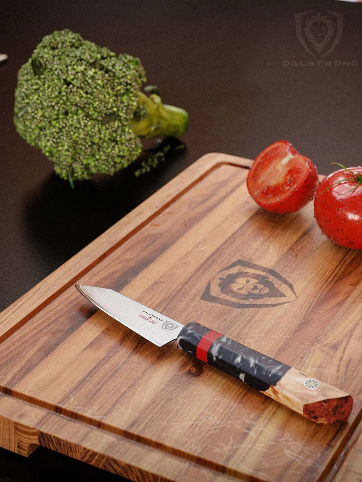 Dalstrong firestorm alpha series 3.75 inch paring knife with tomatoes and broccoli on a cutting board.