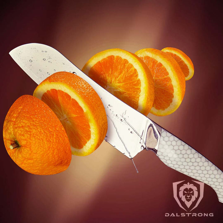 Dalstrong frost fire series 7 inch santoku knife with white handle and five slices of orange.