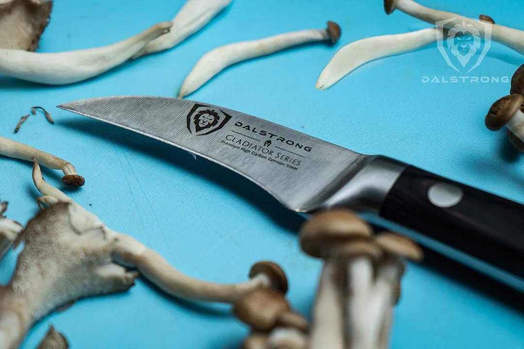 Dalstrong gladiator series 2.7 inch bird's beak paring knife with black handle and mushroom sprouts.