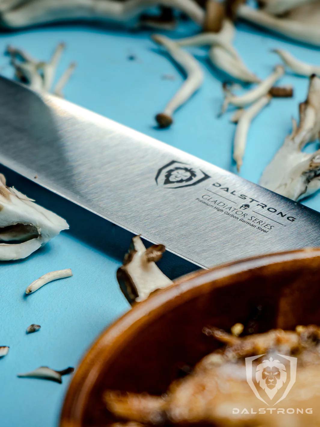 Dalstrong gladiator series 8.5 inch kiritsuke knife showcasing it's series and dalstrong logo on a blue cutting board.