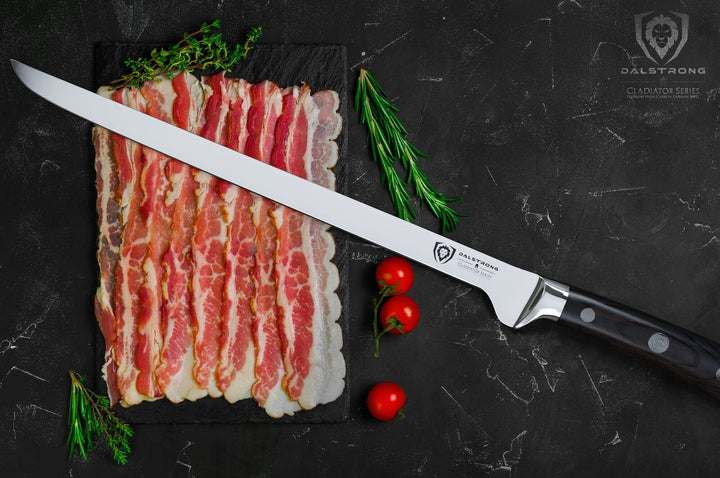 Dalstrong gladiator series 12 inch spanish slicer knife with black handle and sheath inside beside slices of bacon.