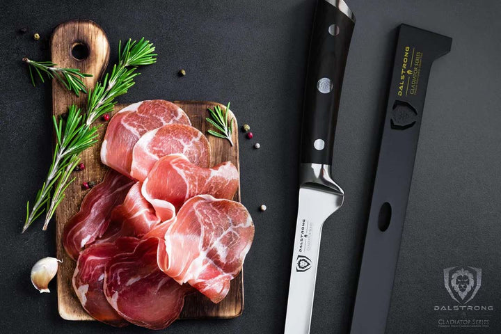 Dalstrong gladiator series 12 inch spanish slicer knife with black handle and sheath inside beside slices of ham.