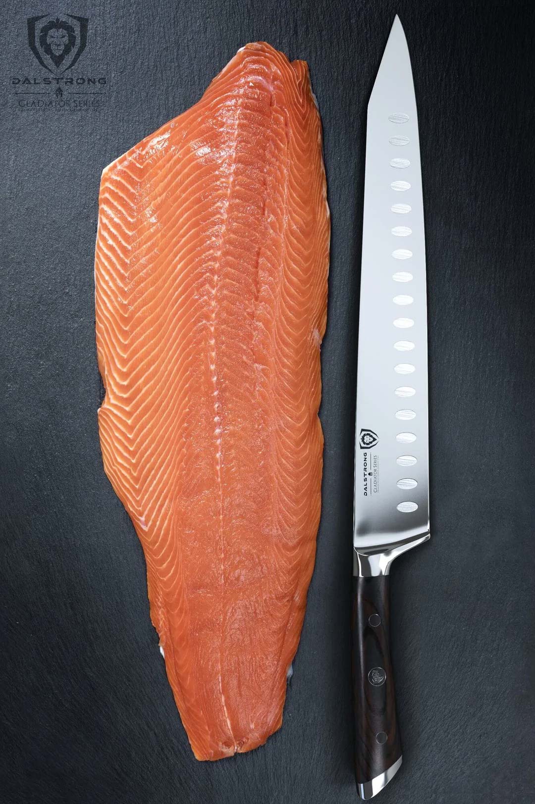 Dalstrong gladiator series 12 inch sujihiki knife with black handle and a fillet of salmon.