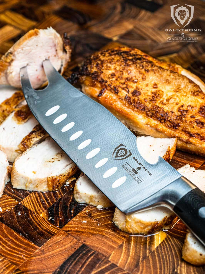 Dalstrong gladiator series 6.5 inch pitmaster knife with blach handle and slices of cooked chicken meat.