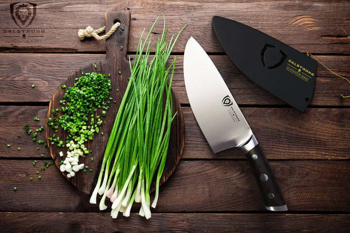 Dalstrong gladiator series 7 inch rocking herb knife with black handle and sheath beside some chopped scallions.