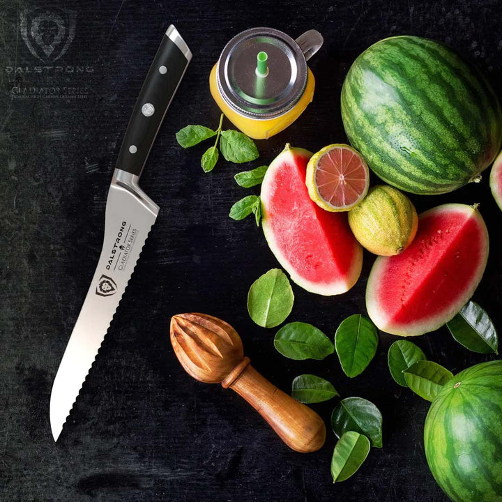 Dalstrong gladiator series 8 inch serrated offset bread knife with black handle with sliced watermelons beside it.