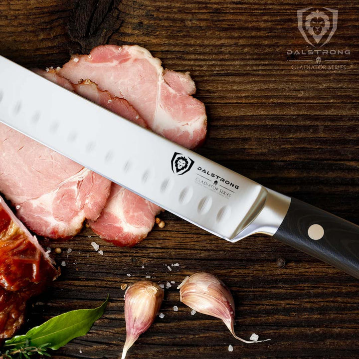 Dalstrong gladiator series 8 inch slicer knife with black handle and slices of cooked meat on a wooden table.