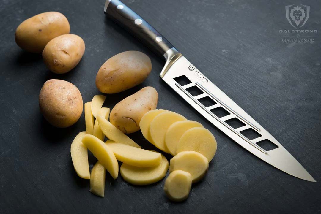 Dalstrong gladiator series 8 inch vegetable knife with black handle and slices of potatoes beisde it.