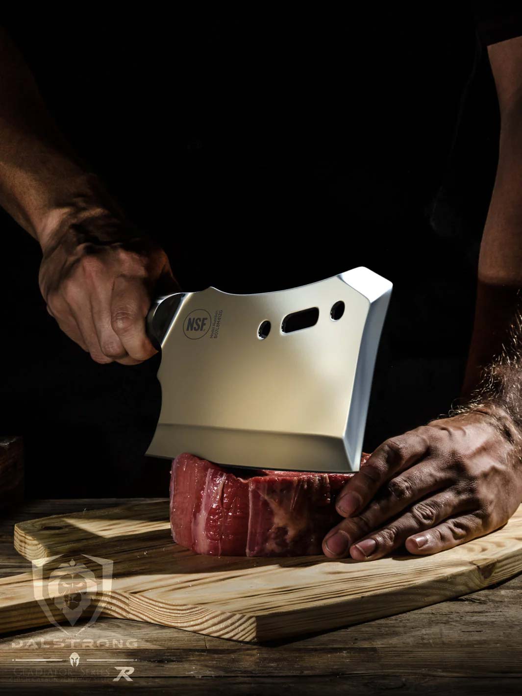 Dalstrong gladiator series 9 inch obliterator cleaver knife with black handle and a large cut of meat on a wooden board.