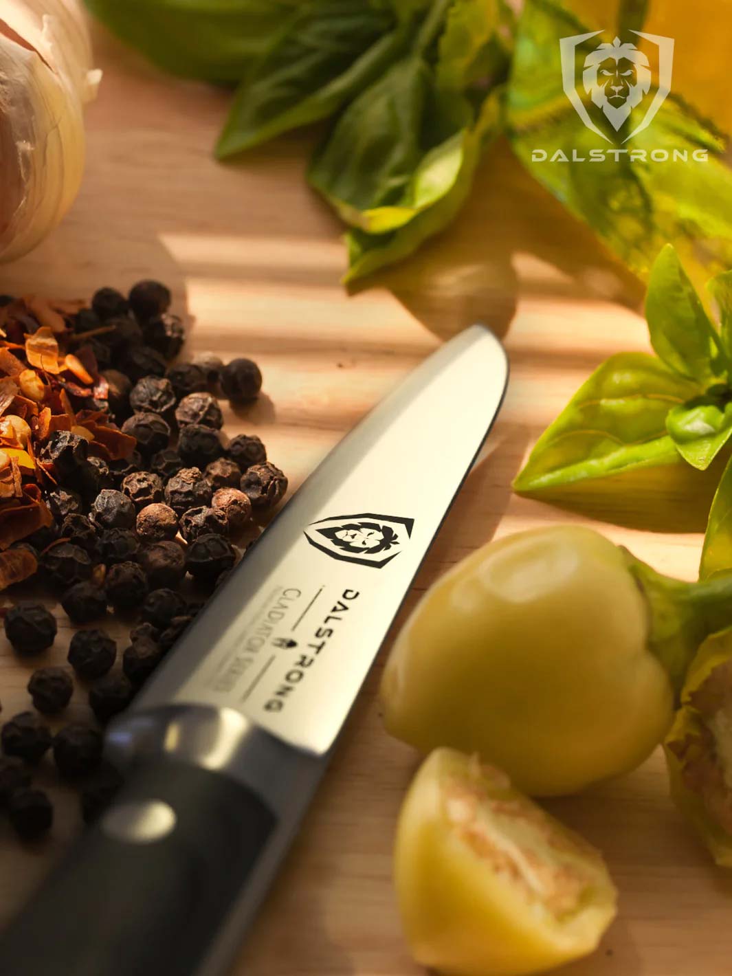 Dalstrong gladiator series 3.5 inch paring knife with black handle in the middle of black peppers and tomatoes.