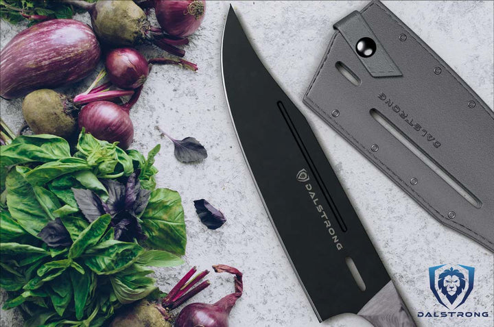 Dalstrong delta wolf series 8 inch chef knife with black blade and sheath beside some vegetables.