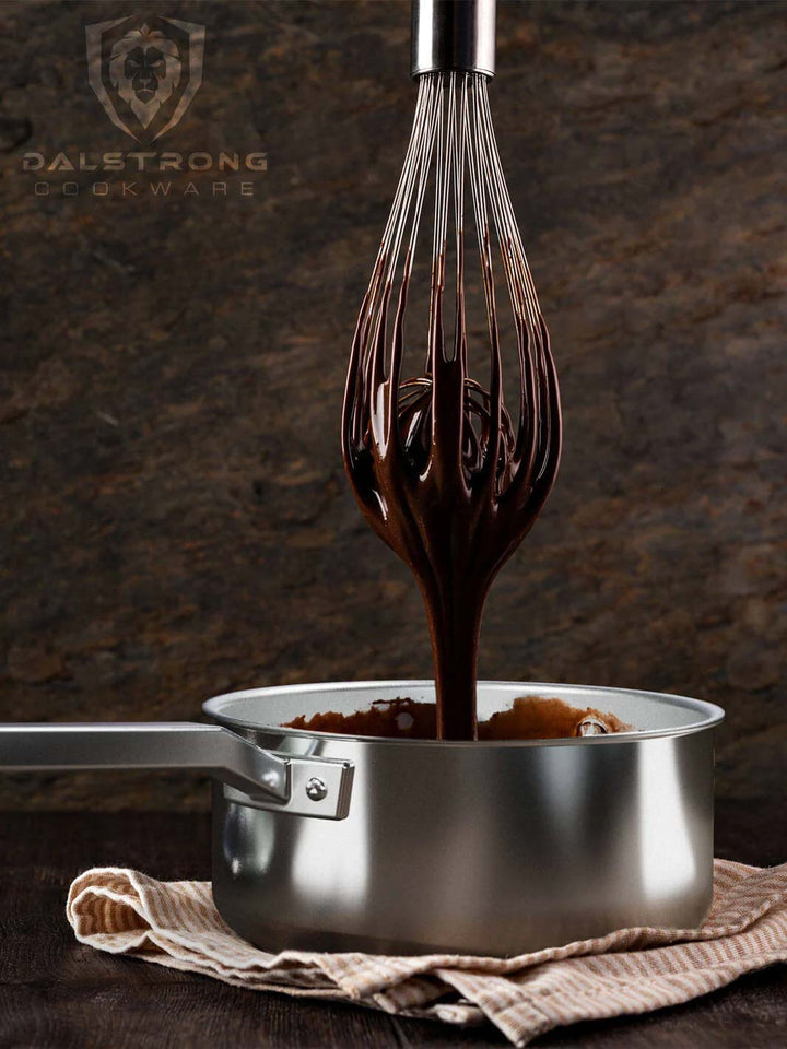 Dalstrong oberon series 4 quart stock pot silver with wire wisk covered with chocolate.