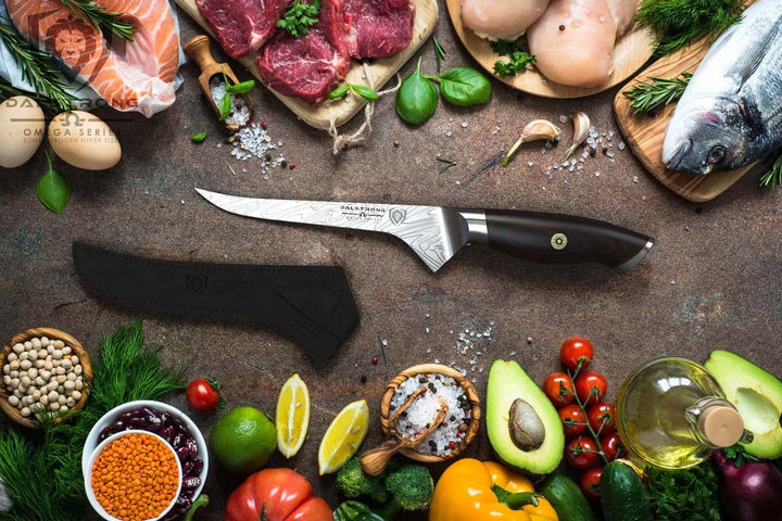 Dalstrong omega series 6 inch straight boning knife surrounded by meats and vegetables.